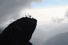 a group of people standing on top of a mountain with their hands in the air