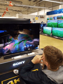 a man is sitting in front of a sony tv