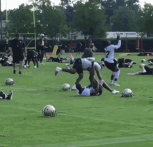 a group of football players are practicing on a field with a sign that says value treasures in the background