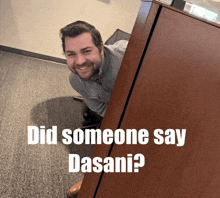 a man peeking out from behind a wooden cabinet with the words did someone say dasani below him