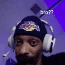 a man with a beard wearing headphones and a hat with a lakers logo on it .