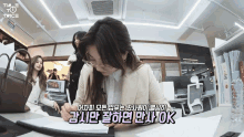 a twice video shows a woman writing on a piece of paper in a room