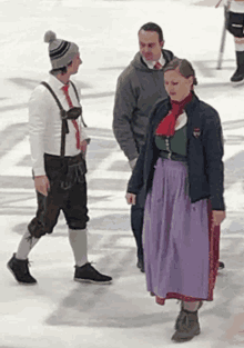 a woman in a purple skirt talks to a man in a white shirt