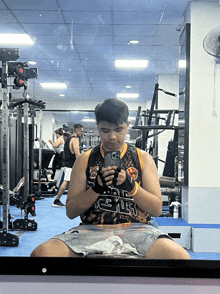 a man taking a picture of himself in a gym wearing a shirt that says ' jesus '