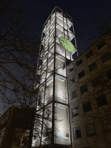 a tall building with a green clock on the top of it