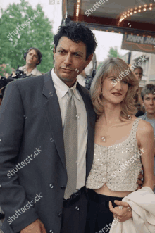 a man in a suit and tie is standing next to a woman