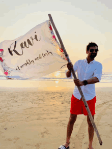 a man holds up a flag that says kawi on it