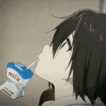 a person drinking milk through a straw from a carton