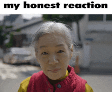 a woman in a red vest stands in front of a sign that says ' my honest reaction '