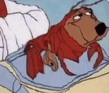 a cartoon dog is laying on a bed with a lobster 's legs .