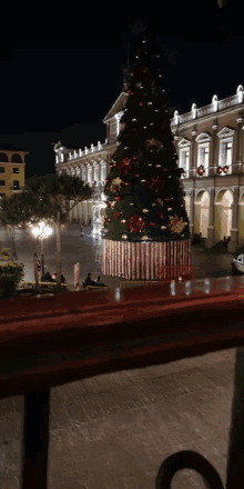 a large christmas tree in front of a building