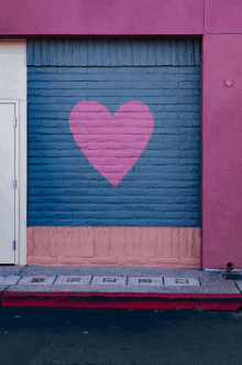 a pink brick wall with a heart painted on it