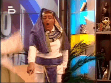 a man dressed as a pharaoh is yawning in front of a sign that says u.