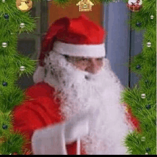 a man dressed as santa claus is standing in front of a christmas tree and a door .