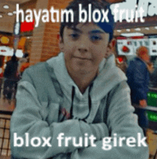 a young boy is sitting at a table with his arms crossed and a caption that says blox fruit girek .