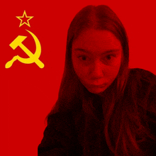 a girl is taking a selfie in front of a red background with a hammer and sickle and a star