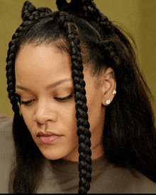 a close up of a woman 's face with braids