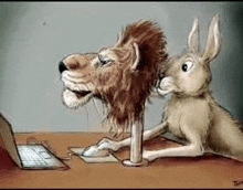 a lion and a rabbit are sitting at a desk looking at a laptop computer .