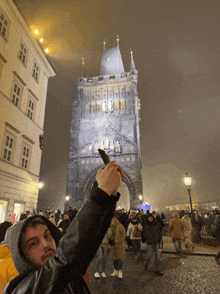 a man in a hoodie takes a picture of a tower