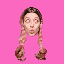 a woman with pigtails is making a face on a pink background