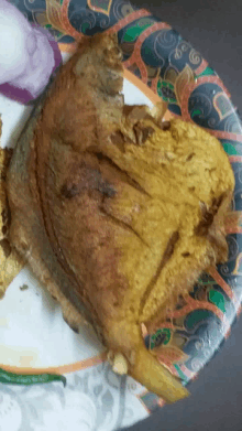 a paper plate with a piece of fried meat on it