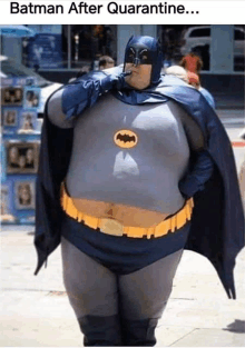 a fat man dressed as batman smoking a cigarette