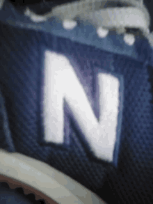 the letter n is embroidered on the side of a blue shoe