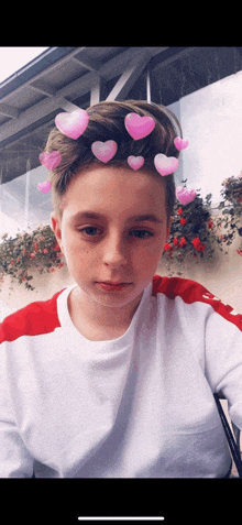 a young boy with hearts in his hair takes a selfie