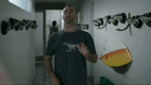 a man wearing a shirt with a fox on it stands in a hallway