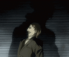 a man in a suit is standing in front of a wall and his shadow is visible