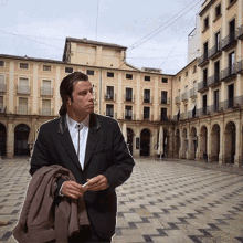 a man in a suit and tie is standing in front of a building that says ' plaza ' on it