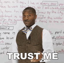 a man in a vest and bow tie stands in front of a whiteboard that says " trust me "