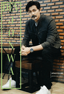 a man sits on a wooden stool in front of a brick wall with the words photolab written on the bottom