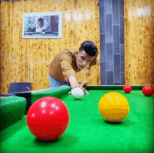 a man is playing pool on a green table