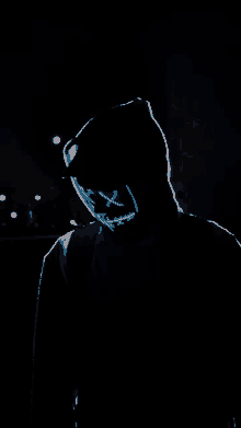 a person wearing a neon mask in the dark