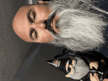 a bald man with a beard is standing next to a harley davidson figurine