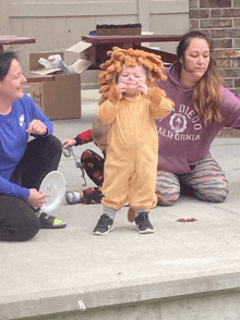 a woman in a diego california sweatshirt sits next to a child