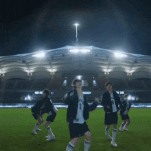 a group of soccer players are jumping in the air in front of a stadium with fireworks in the background