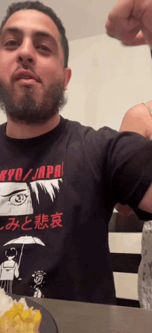 a man with a beard wearing a shirt that says kyo japan