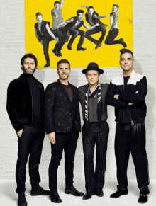 a group of men are standing in front of a yellow sign that says ' nsync ' on it