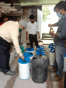 a man wearing a mask is pouring liquid into a barrel that says ' shree ram ' on it