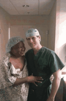 a woman in a hospital gown is being hugged by a doctor