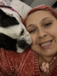 a woman in a red sweater with a black and white dog