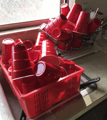 a basket full of red cups sits on a kitchen counter