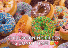 a bunch of colorful donuts with sprinkles on them are sitting on a table .