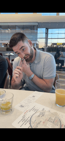 a man sitting at a table with a glass of beer and a menu