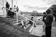 a black and white photo of a group of people standing on stairs