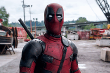 a man in a deadpool costume with a sword on his shoulder