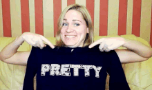 a woman is pointing at a shirt that says pretty on it