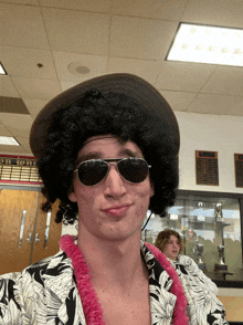 a man wearing a wig and sunglasses is standing in front of a sign that says ' champions '